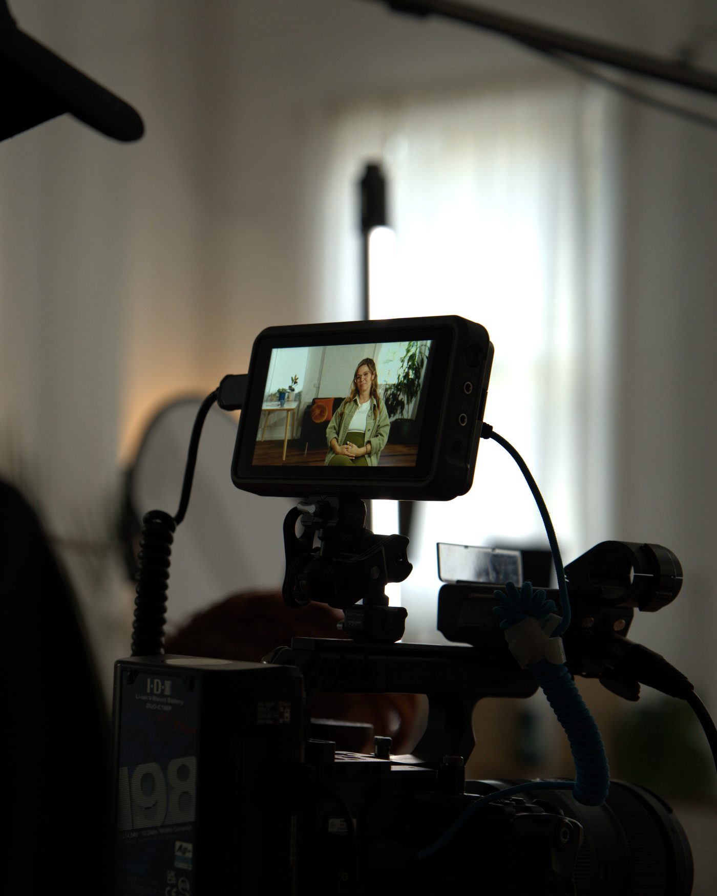 Over the operator&rsquo;s shoulder, the monitor bright with the framed subject.