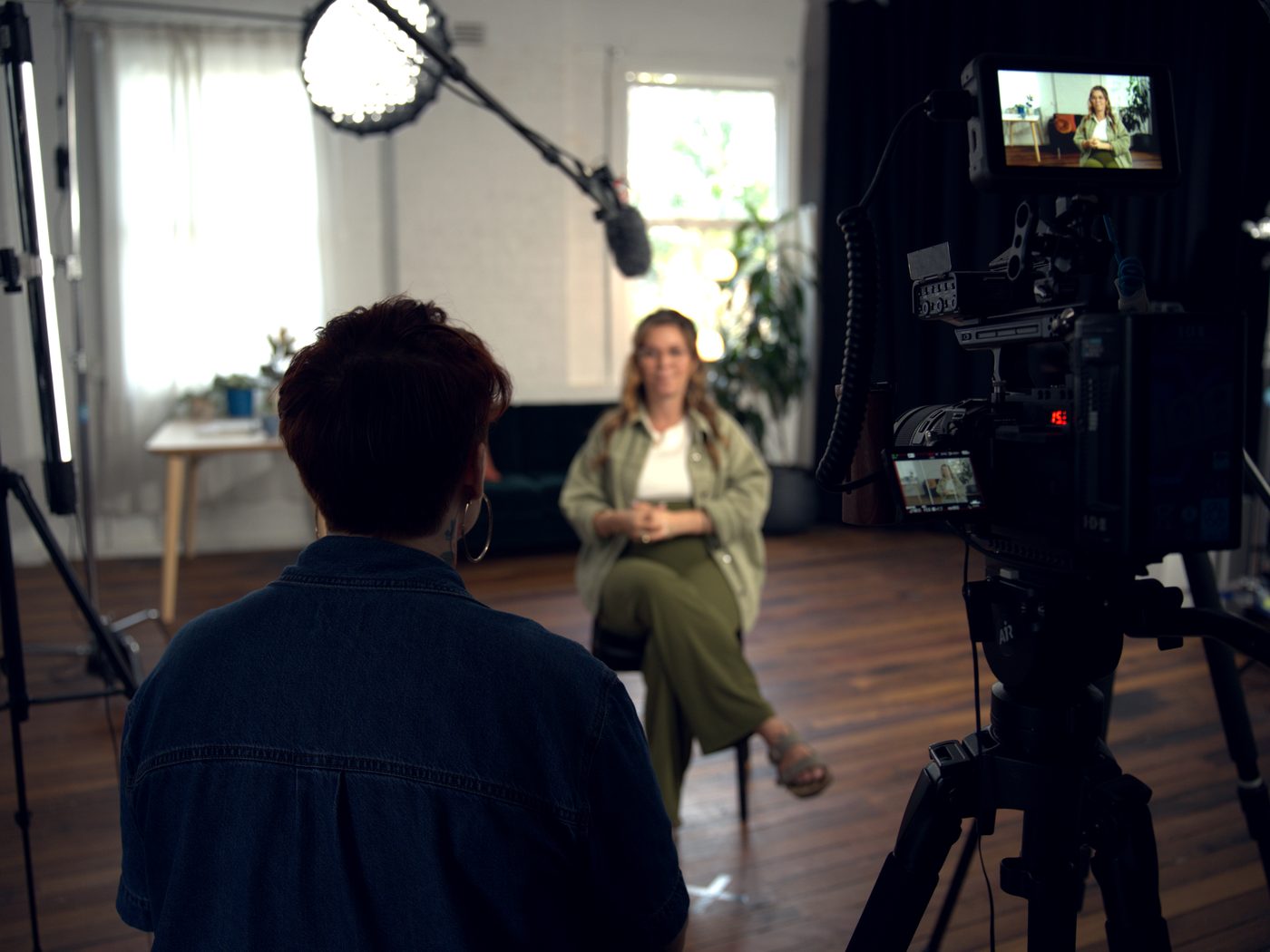 The same kind of interview being made. The monitor beside the camera holds the framed shot while the set around it is full of stands, cables and crew.